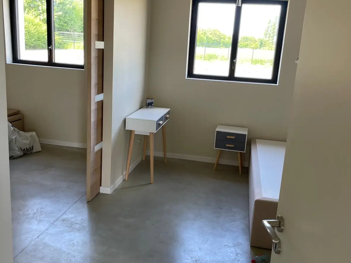 Espace neuf à sol béton ciré et poutres bois, nettoyé