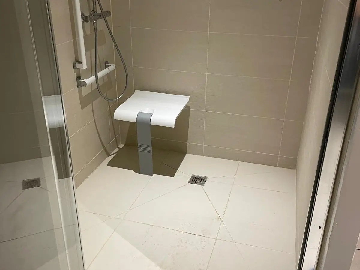 Douche italienne PMR avec siège et barre d'appui