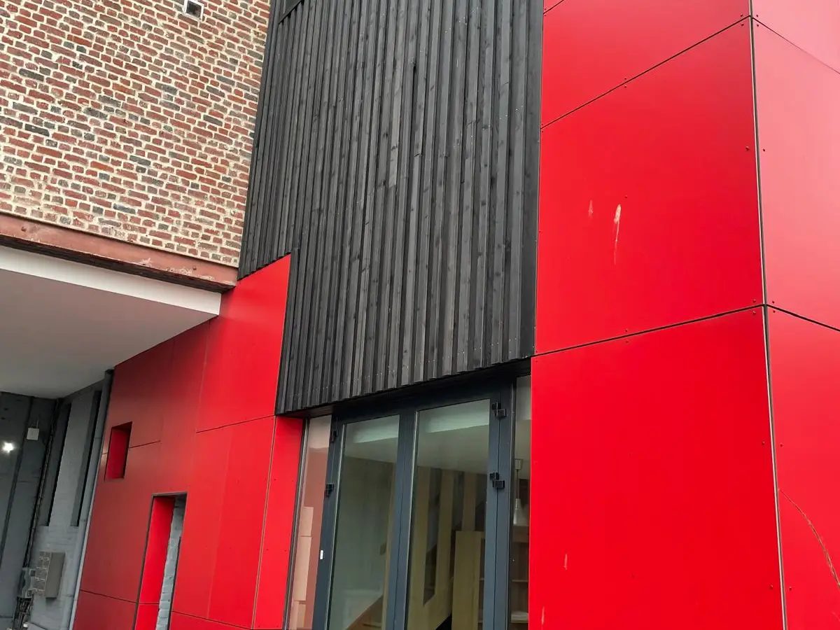 Façade rouge et noire d'un bâtiment, accès commun
