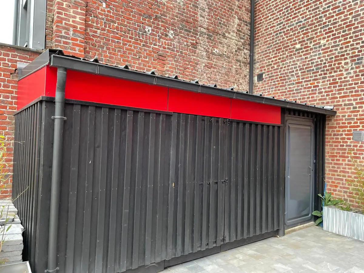 Façade rouge et noire d'un bâtiment, accès commun